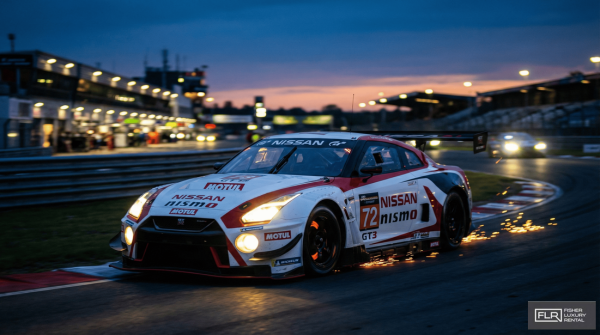 Nissan GT-R GT3 race car competing in an endurance race at dusk.